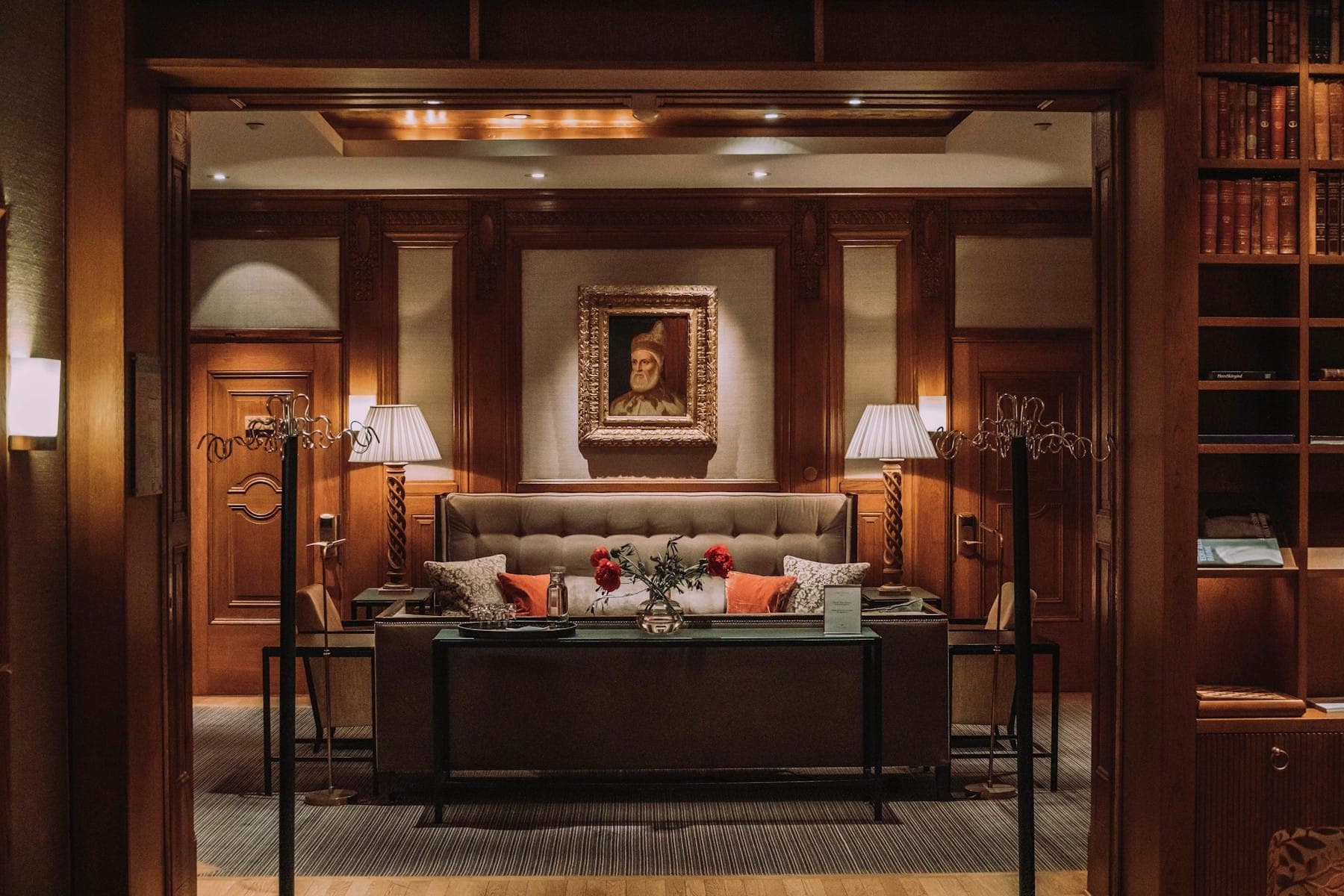 A warmly lit hotel suite with wood-panelled walls